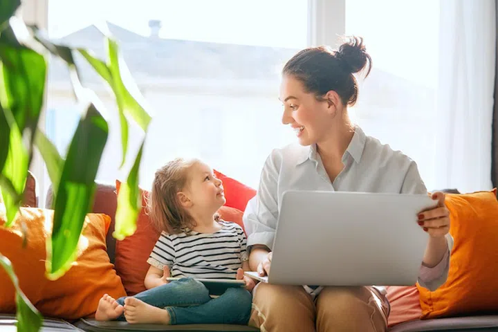 Happy loving family. Young mother and her daughter girl play in room. Funny mom and lovely child are having fun with laptop.