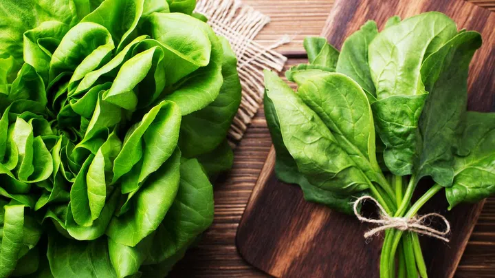Vegetables, salads, beetroot, spinach. On a wooden background.
