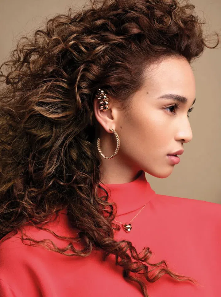 Silk top, Valentino; Clash the Cartier pink gold XL single earring, Clash the Cartier pink gold medium hoop earrings, and Panthere de Cartier yellow gold tsavorite garnets and onyx necklace