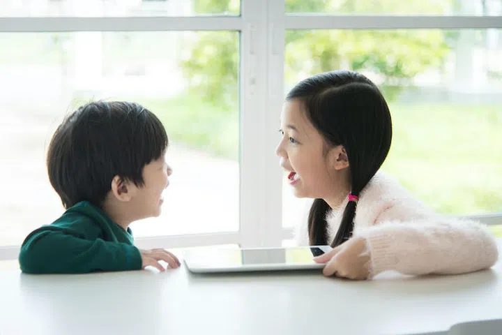 Portrait of happy asian children with tablet on white table