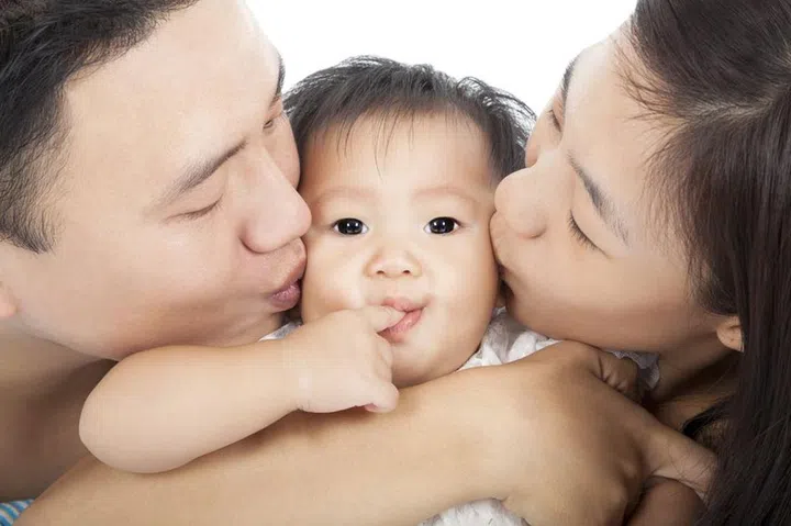 21492427 - happy  family kissing the baby