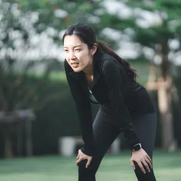 Young Asian women sports tired after exercise and runs at public park.