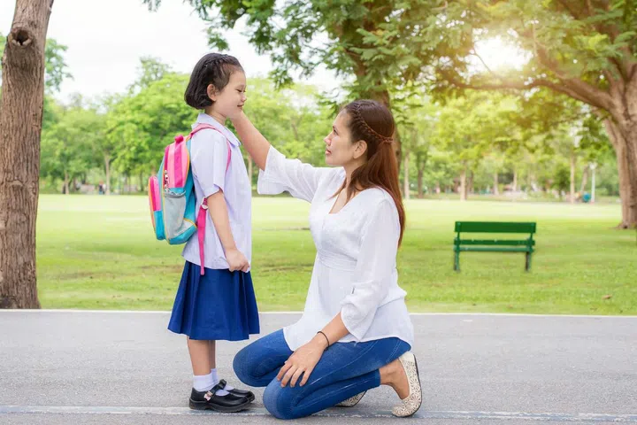 Back to school. Happy Asian mother with kids student in school. Asian mother adjusting kids student shirt in school.
