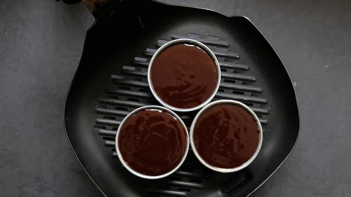 04. Add a coat of butter to your containers to aid easy removal of your cakes later. Add the mixture to your containers.
04. Preheat air fryer at 160 C for 5 mins and cook for 2 to 3 mins, removing it from the air fryer once you see that the top is cooked and looks solid.
04. Remove from air fryer, flip it over and your lava cake will be ready for consumption.