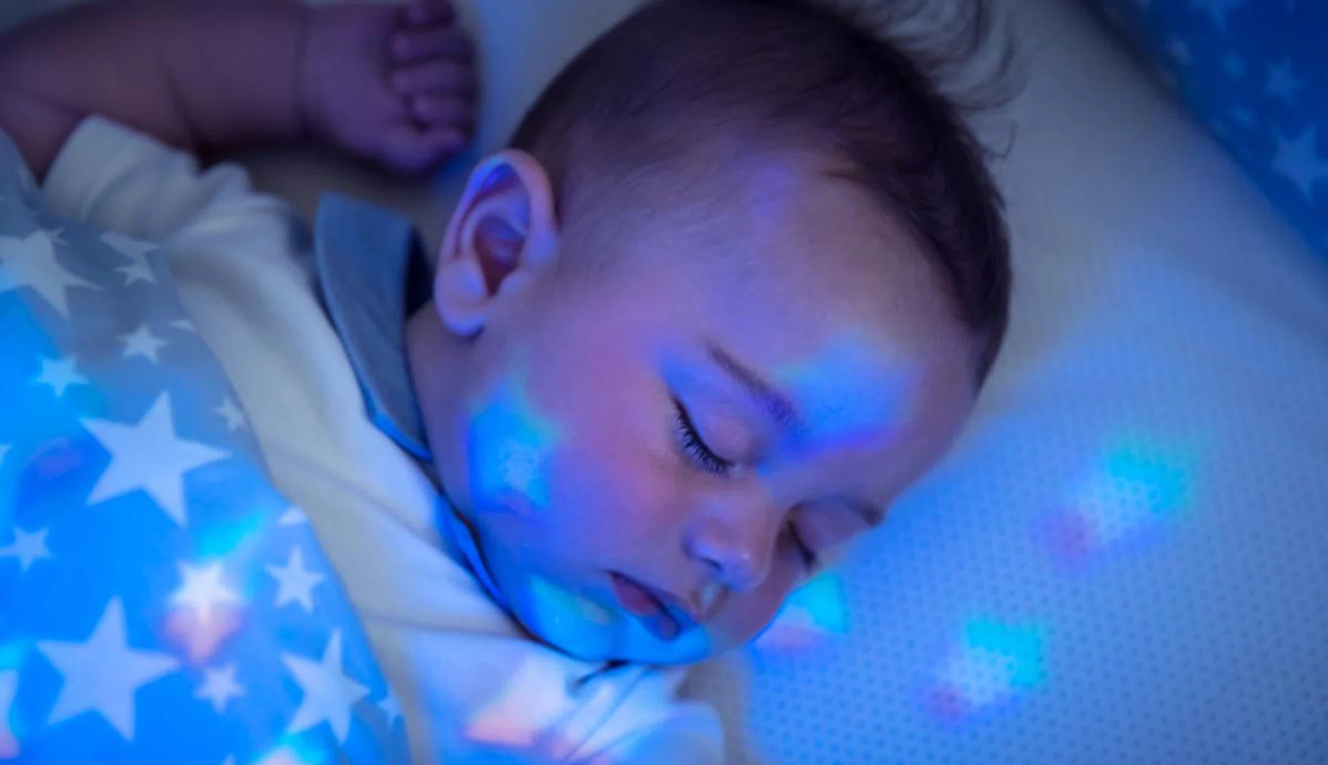 Portrait of nice sleeping baby boy, pretty child resting in his bed, star-shaped night light, healthy and peaceful childhood, new life concept