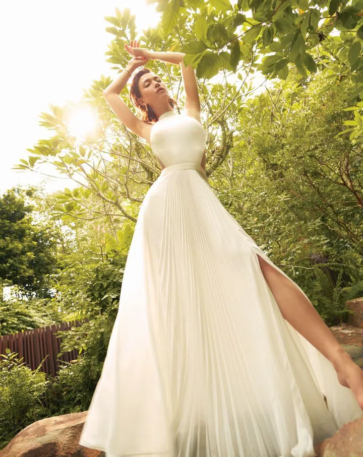 Pleated gown from Ralph Lauren; Yellow gold Panthère de Cartier earrings and Panthère de Cartier diamond bangle, both from Cartier.  