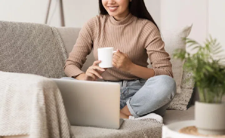 Happy Girl Relaxing on Comfortable Couch and Using Laptop at Home, Surfing Internet