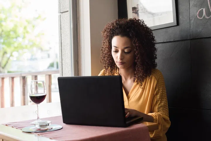 Casual woman using laptop at coffee shop