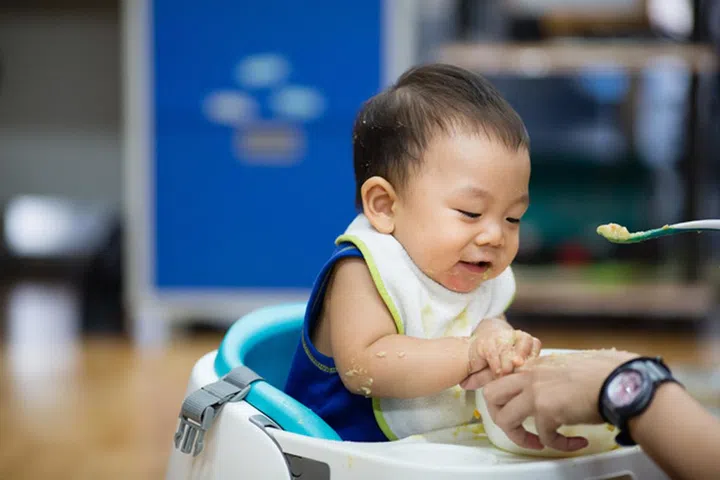 curious and playful baby boy examines and eating baby serial