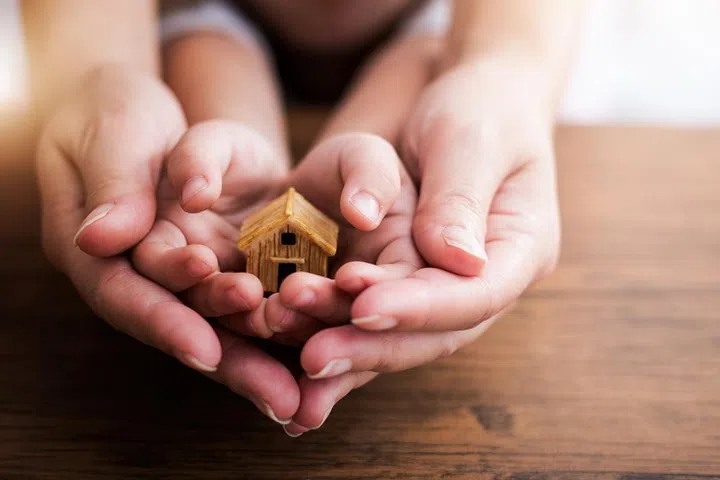 Home concept,people, family and home concept - close up of woman and girl holding model house