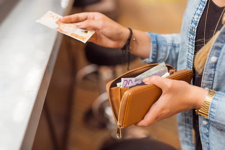 Woman paying with cash at bar
