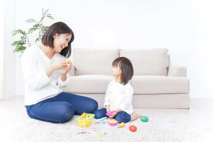 Child playing with toy with mother