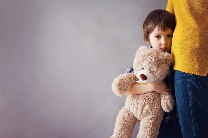 Sad little child, boy, hugging his mother at home, isolated image, copy space. Family concept