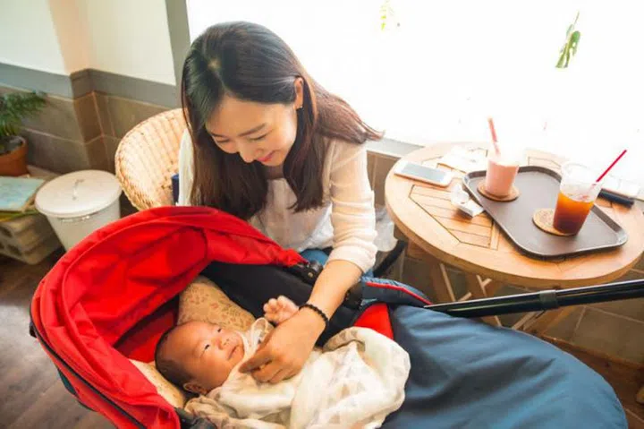 Asian young mother looking after her baby