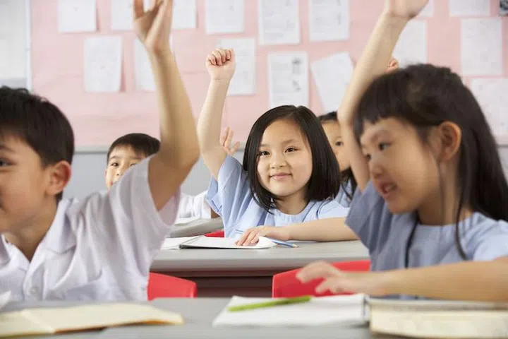 18709515 - group of students working at desks in chinese school classroom