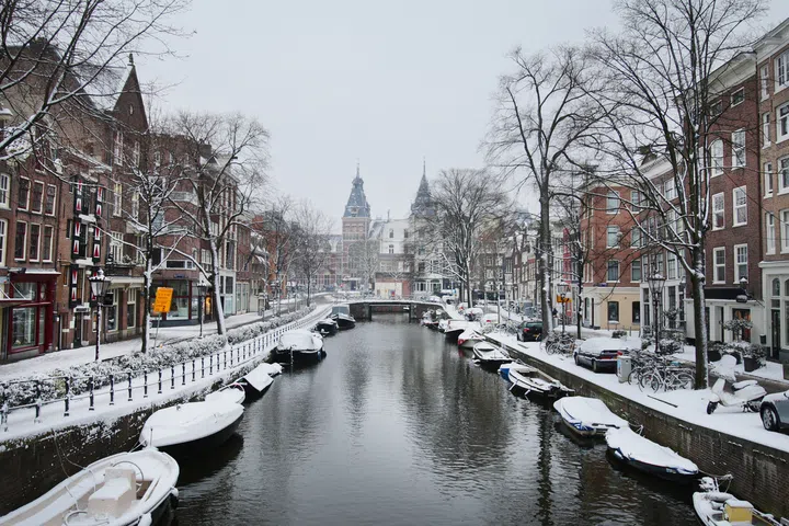 Snow covered thes stree with bicycles parked on the bridge over Prinsegracht canal in Amsterdam,Netherlands.