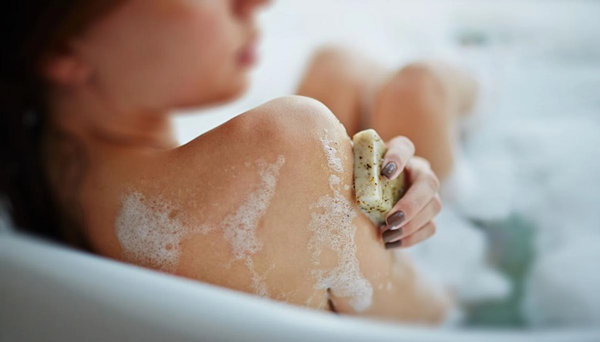 Woman washing herself in a bathtub
