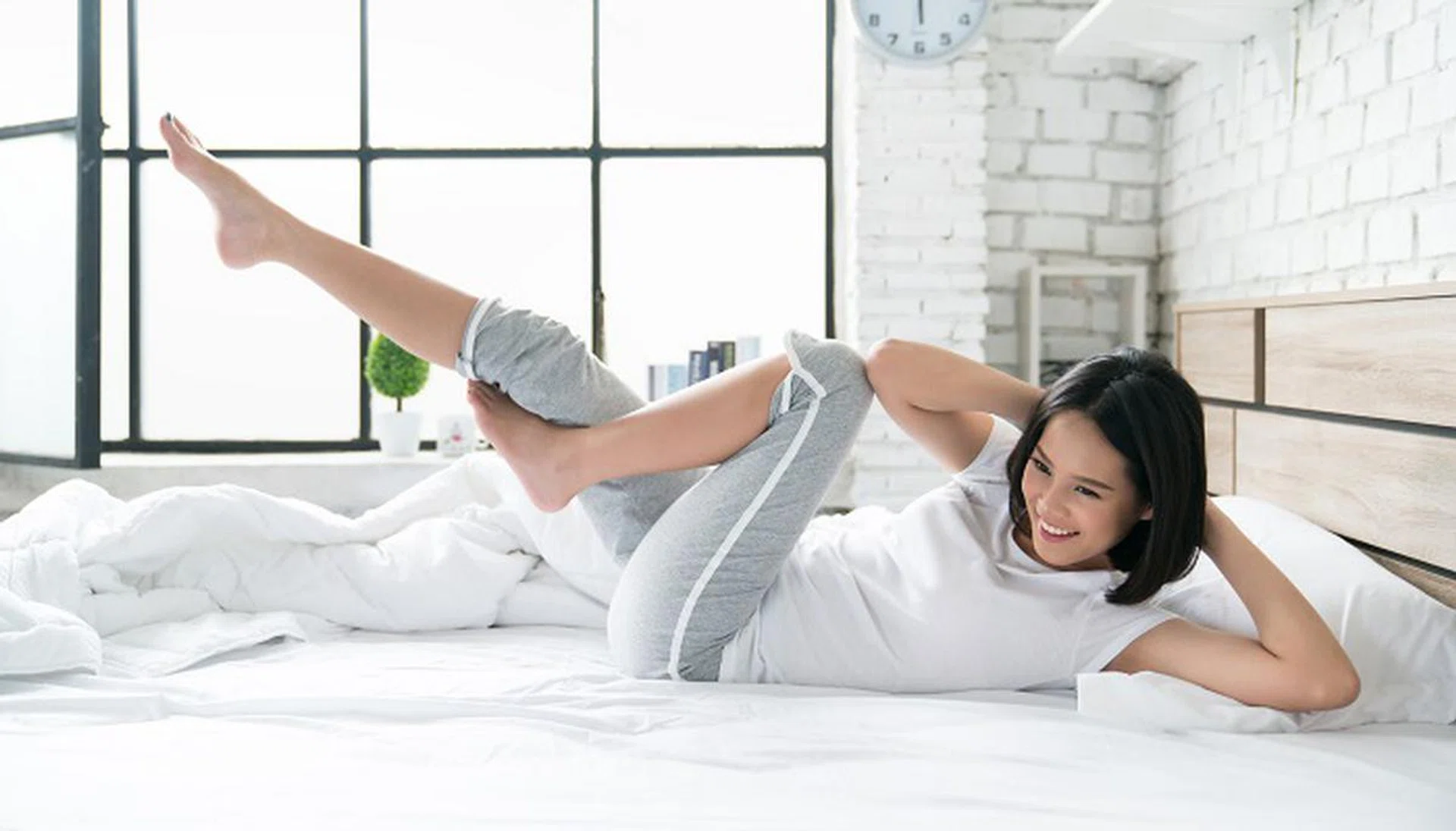 Asian women exercising in bed in the morning, she feels refreshed.