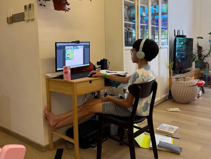 My eldest son Gabriel doing his home-based learning school work on the family computer in the living room. Image: Kelly Ang