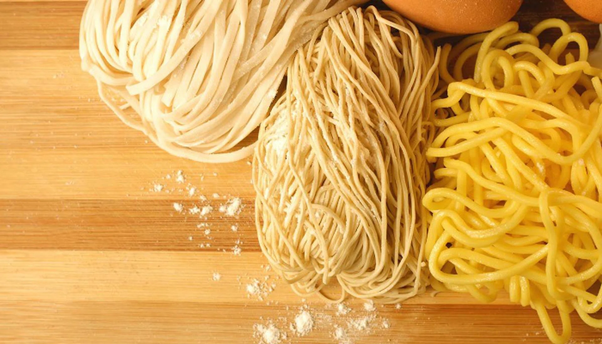 Handmade noodles and ingredients on chopping block. Noodles are an essential ingredient and staple in Chinese cuisine. 
