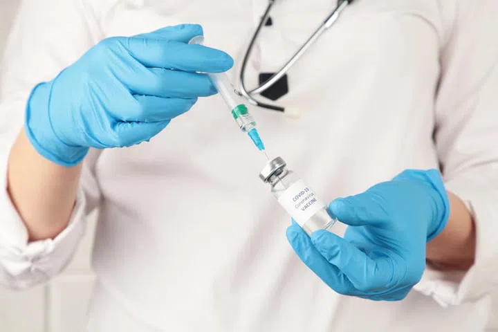 Concept fight against virus covid-19 corona virus, doctor in laboratory holding a syringe with liquid vaccines.