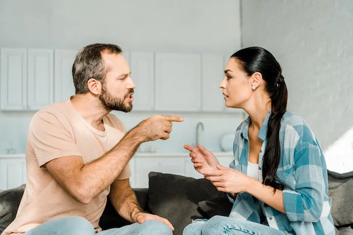 couple having argument and husband yelling at wife at home