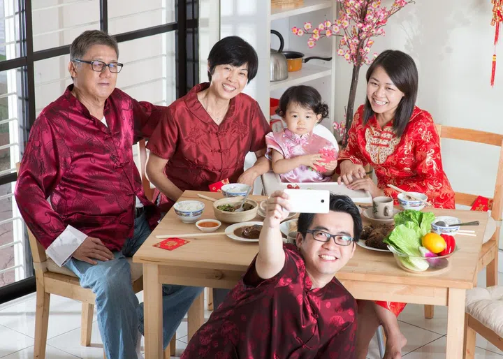 43523070 - chinese new year celebration, reunion dinner. happy asian chinese multi generation family with red cheongsam selfie while dining at home.