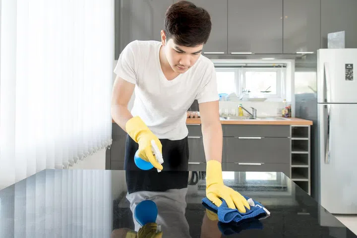 51691926 - asian young man cleaning modern kitchen at home