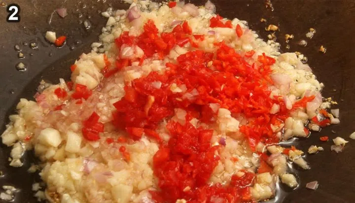 04. In a wok or pan, heat the oil on medium heat. Add the garlic, shallots, chilli padi and red finger chilli.