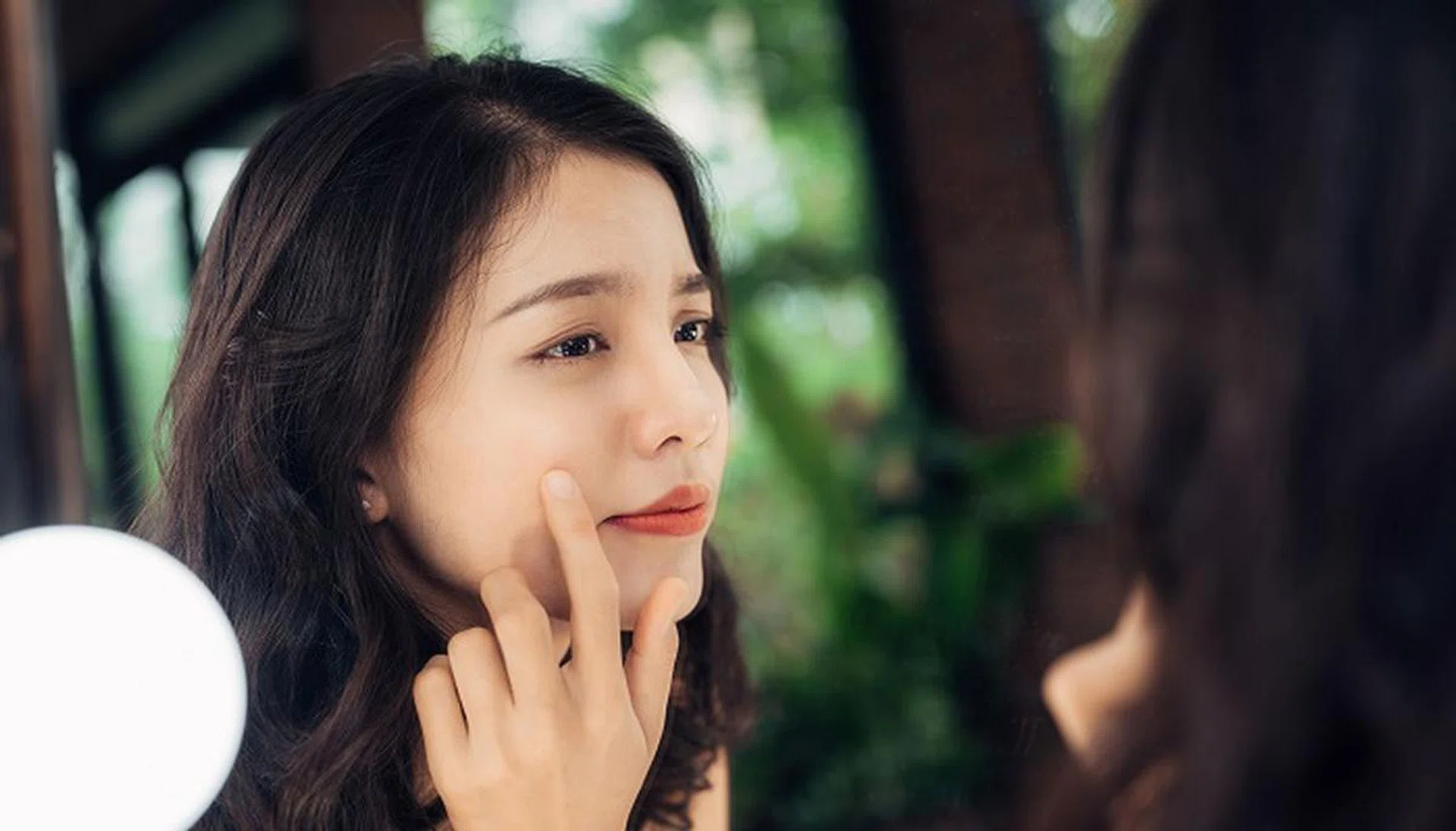 82078464 - beauty, skin care lifestyle concept. young asian woman with acne looking at the mirror.