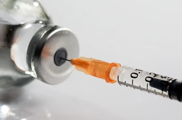 macro photography of a syringe ready to put a vaccine