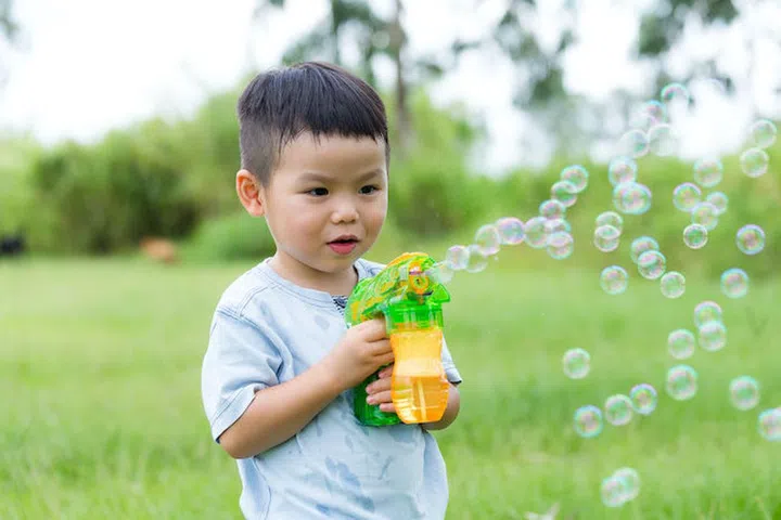 Asian boy play with bubble blower