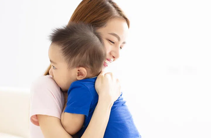 Close Up Of Mother Cuddling Baby son At Home