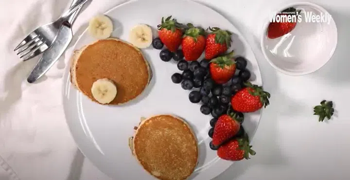 01. Using sliced bananas, arrange one slice on each pancake, and two on the sides, with each slice forming the bear’s ears and muzzle.