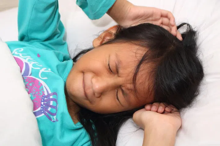 Little Asian girl having nightmare while sleeping
