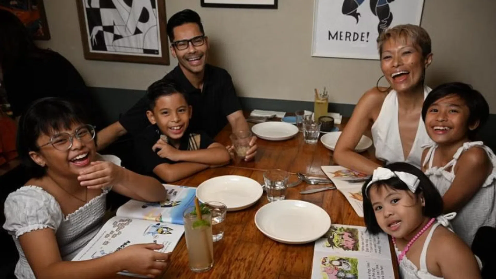 Ms Nichol Ng with her husband Eddy Taps and their children read books while waiting for their lunch at Artichoke restaurant. ST PHOTO CHONG JUN LIANG