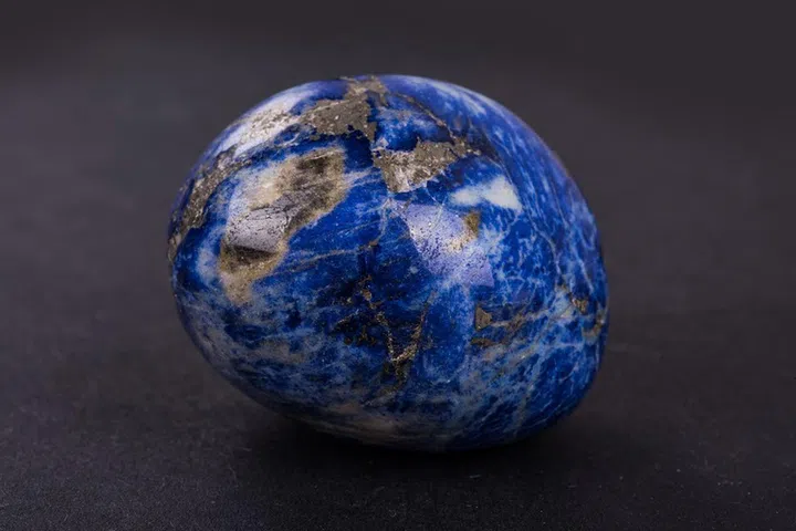Lapis Lazuli geode on black background. Beautiful natural crystal gemstone.