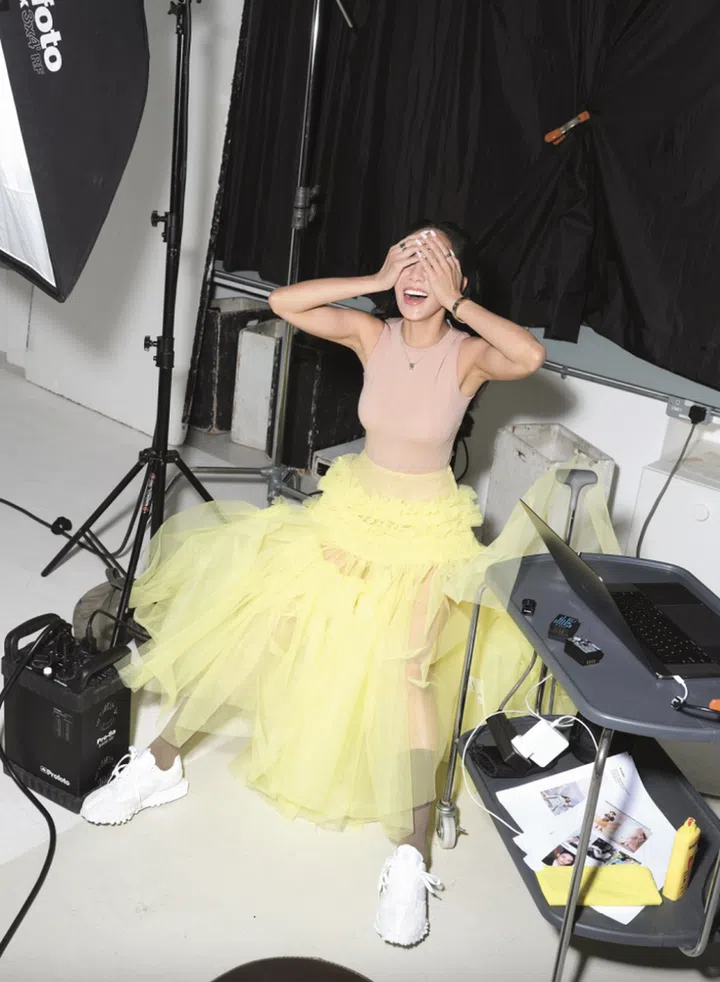 Sleeveless bodysuit, Dior. Tulle maxi skirt, Molly Goddard at Dover Street Market. Cotton socks and XC72 sneakers, New Balance. B.zero1 New Classic white gold necklace, B.zero1 white gold bangle, B.zero1 yellow gold bangle, B.zero1 Labyrinth 4-band white and rose gold ring, and B.zero1 Logo Openwork white gold band ring, Bvlgari