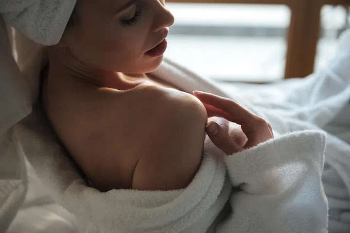 Top view of a sensual young woman in bathrobe posing indoors