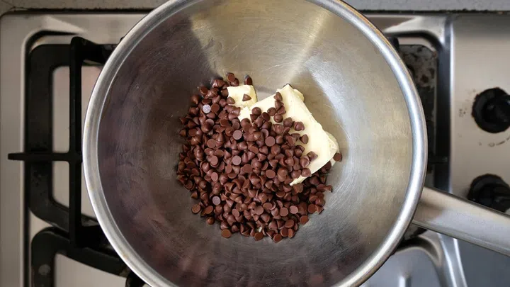 01. Use the double boiler method to melt the chocolate and butter. Heat saucepan filled with water and place a bowl with the chocolate and butter on top. Stir as the heat melts the mixture until smooth.