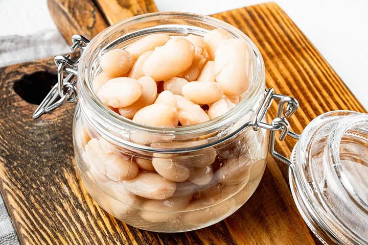 White canned kidney beans set, in glass jar, on white stone surface
