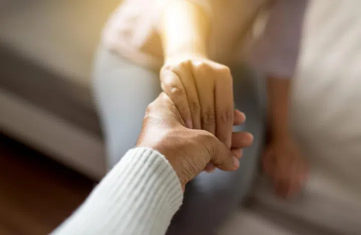 Man giving hand to depressed woman,Psychiatrist holding hands patient,Meantal health care concept,Selective focus