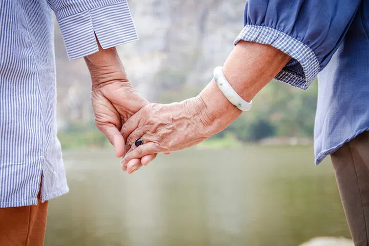 Two Asian senior women hold hands with each other, enjoy traveling, retirement life. Elderly community concept
