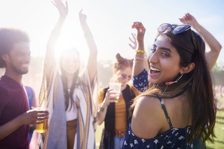 Happy Asian woman and her friends at the music festival