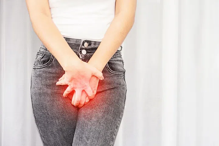closeup woman suffering from pain, itchy crotch hand holding her burning vaginal caused by bladder infections or cystitis
