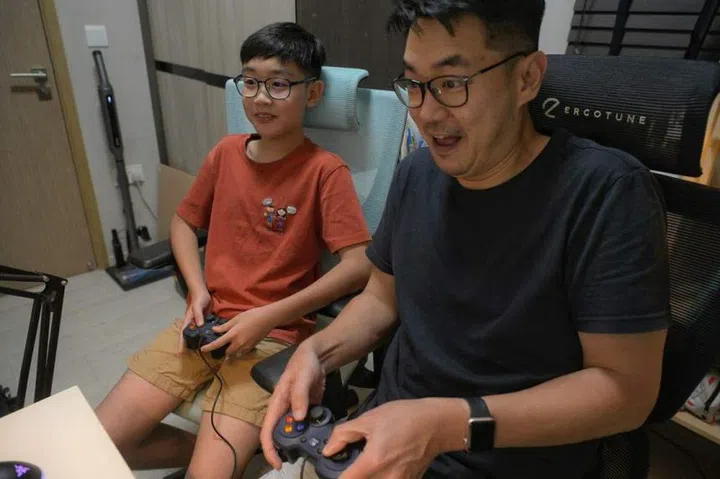 Mr Elvin Foong sometimes plays video games with his 12-year-old son, Nathan, during his study breaks at home. ST PHOTO: MARK CHEONG
