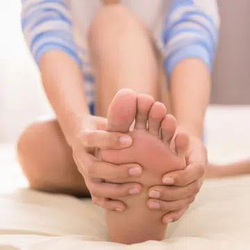 woman holding her foot