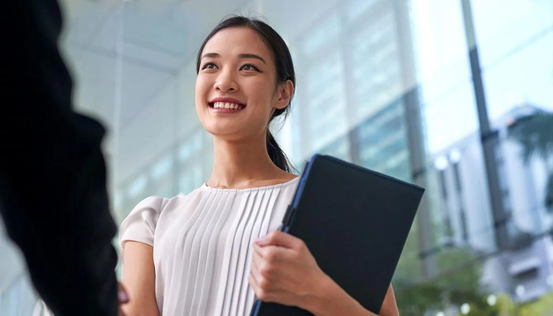 beautiful asian chinese business woman shaking hands in modern city work office