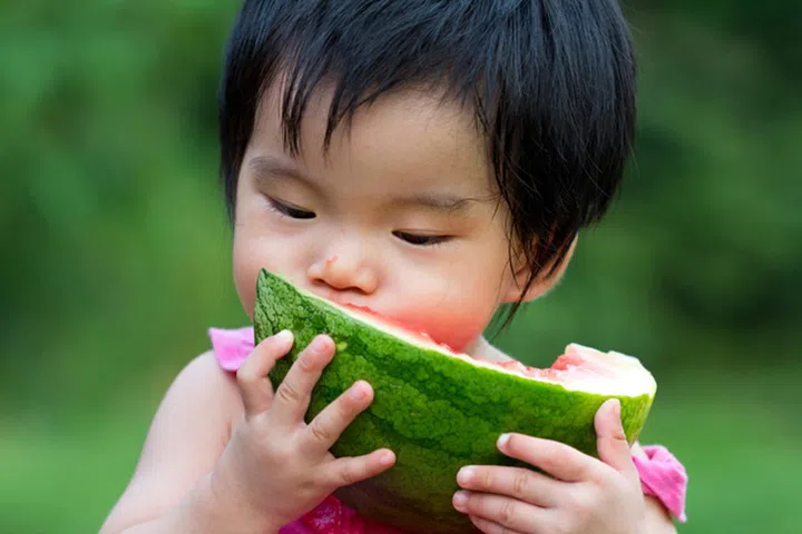 12941866 - little asian baby eating watermelon in park