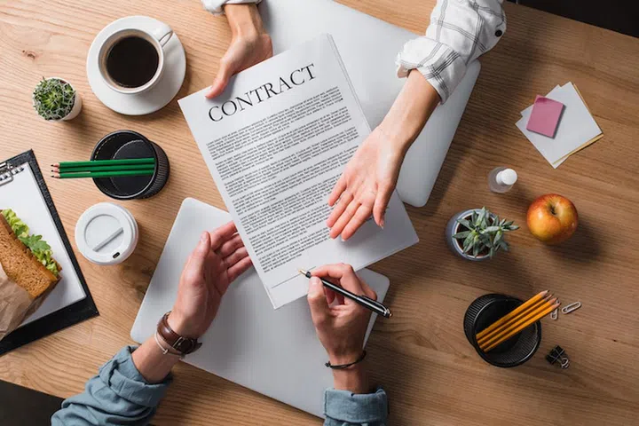 cropped shot of businesspeople signing contract at workplace